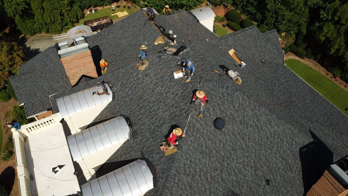 Roof replacement during installation — Landmark Pro Moire Black shingles being laid