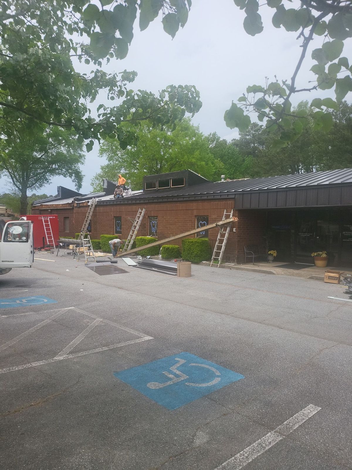 Commercial metal roof installation in progress — new panels being laid across building section
